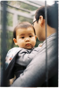 Happy Asian father holding up his cute baby boy