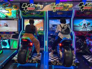 2 girls playing games in a mall