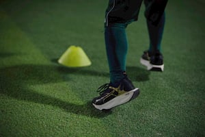 A kid dribbling the ball through obstacle