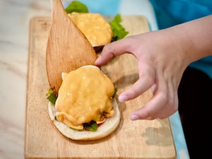Hands preparing a hamburger
