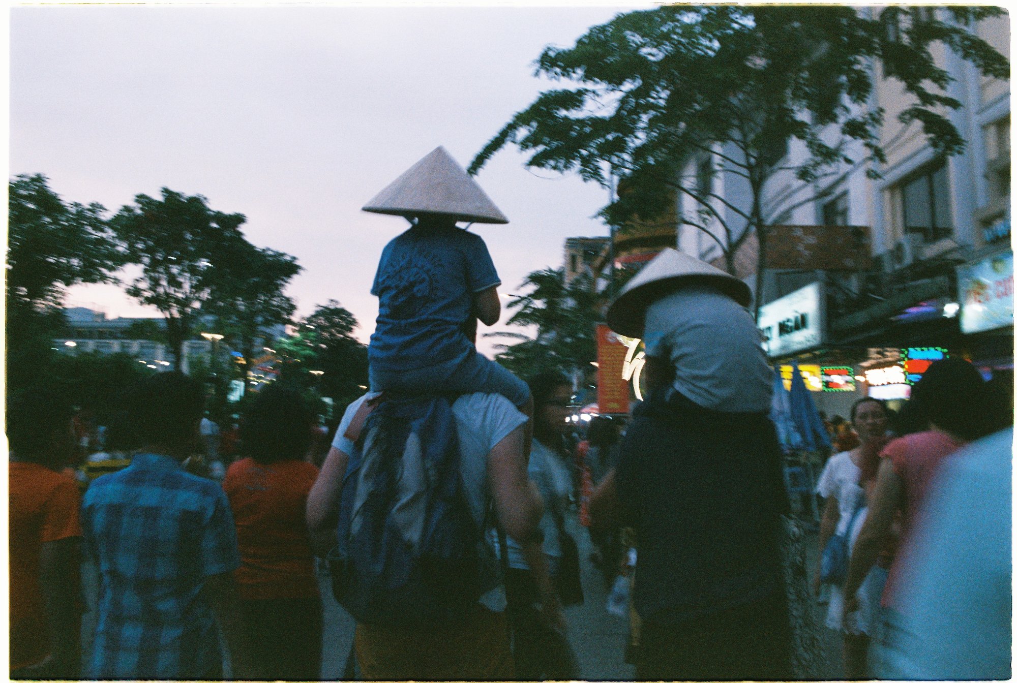 Tourists and locals walking on a lively pedestrian street at night