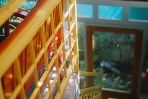 Vibrant yellow and red wooden staircase railing in a vintage house