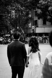 A newly-wed couple holding hands at the cross-road