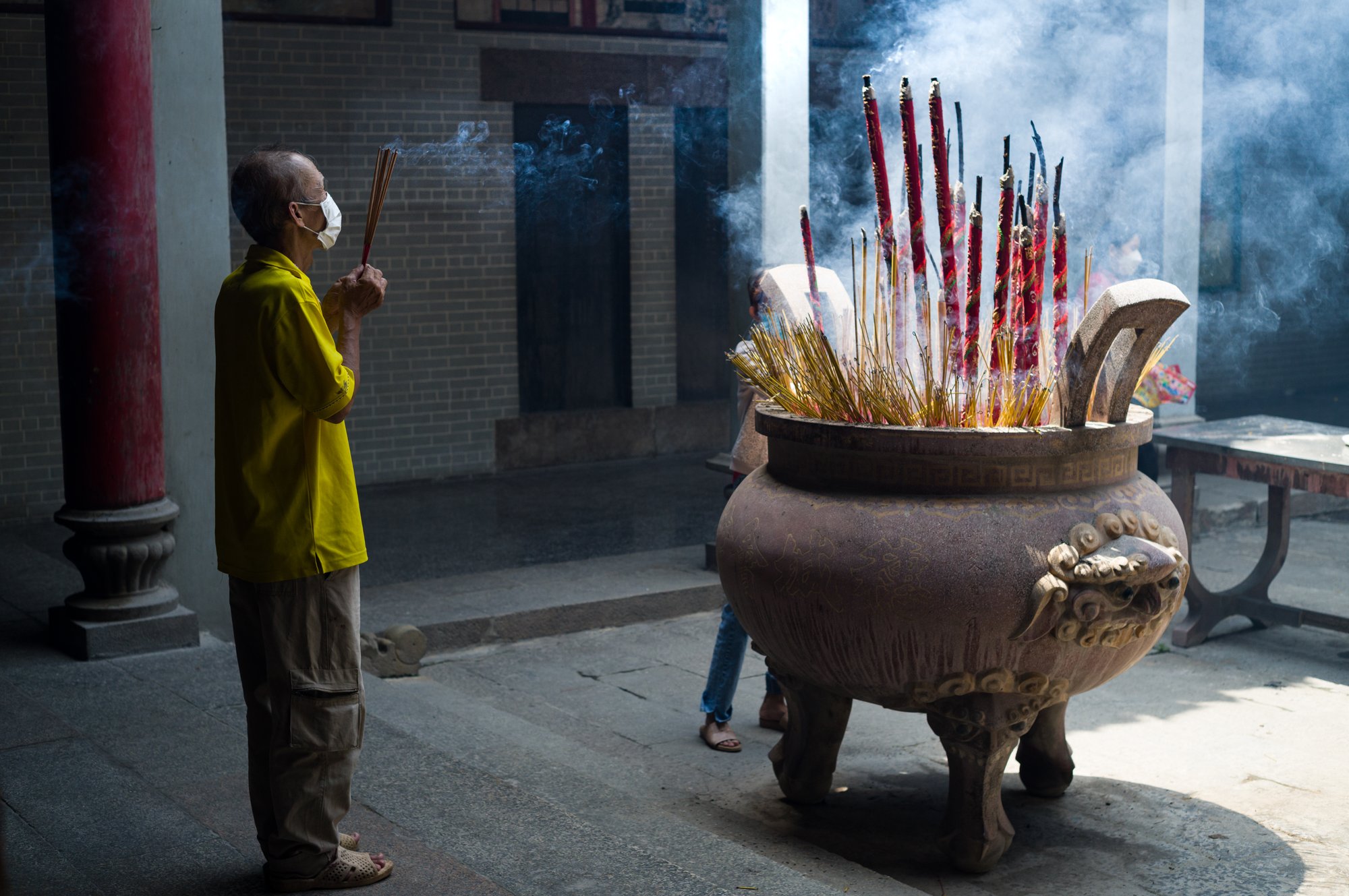Elder man praying with incenses