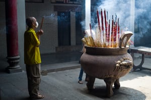 Elder man praying with incenses