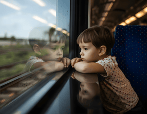 A sad boy sitting in a train