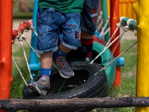 Kids running over tires in colorful playground