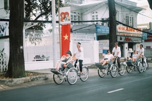 Foreign tourists enjoying a traditional cyclo ride on a street in Vietnam