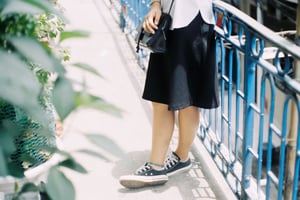 Thời trang thường ngày của một cô gái trẻ với đôi giày vải và túi xách da