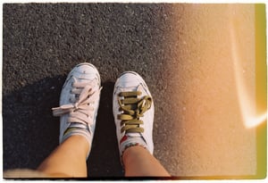 POV shot of feet in casual textile shoes standing on street