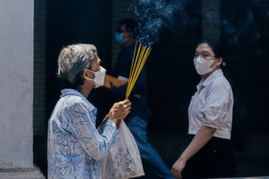 Old woman prauing with incenses in her hands