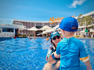 A happy mom playing with her kid in the pool