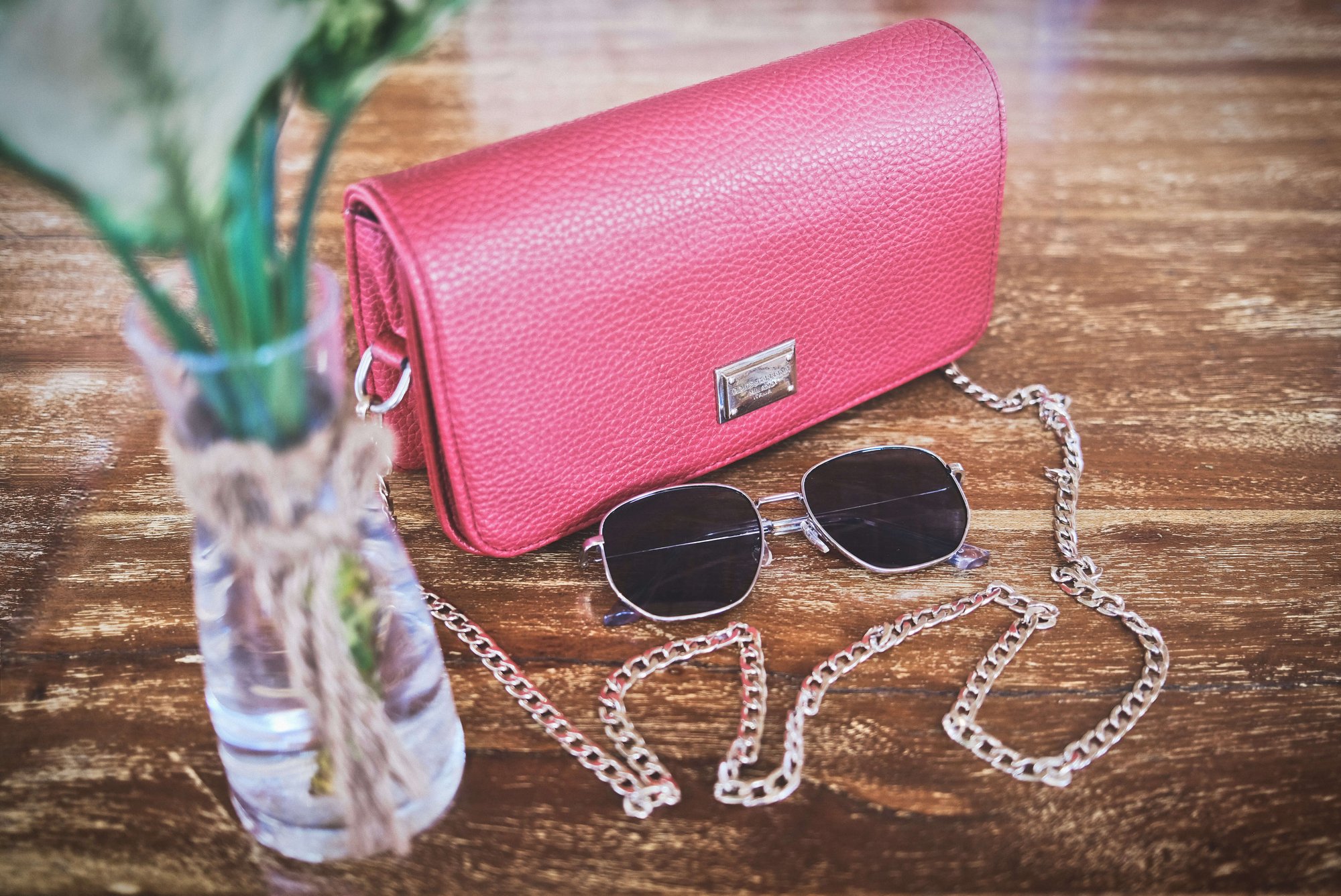 Pink handbag with golden chain and sun glasses