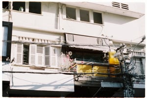 Apartment exterior with balcony flowers under bright daylight