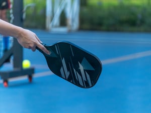 Female hand with a pickleball racket