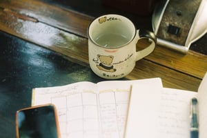 Cozy workspace with calendar, notebook and mug