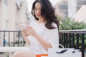 Woman in white t-shirt using smartphone
