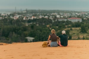 Couples sitting on a sand hill Mui Ne