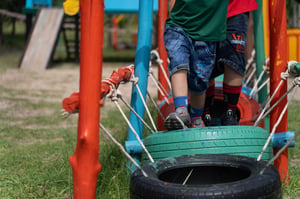 Kids running over tires in colorful playground