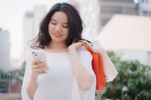 Happy young asian woman using mobile smartphone