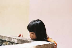 Khoảnh khắc suy tư của cô bé bên bờ tường bê tông