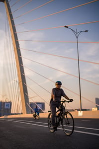 Man riding bicyle on a bridge