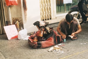 Người thợ sửa giày truyền thống trên vỉa hè đang sửa những đôi giày da