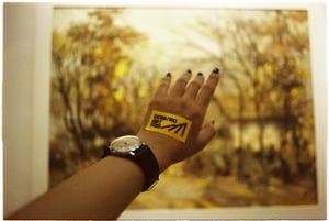 Creative person hand wearing a vintage watch in front of a beautiful impressionism painting