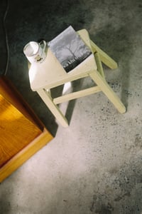 Quyển sách và chiếc cốc gốm trên chiếc ghế đẩu nhỏ