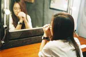 Một cô gái xinh đẹp đang soi gương