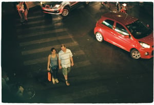 A couple cross the road