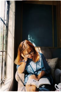 Cô gái đọc sách bên cửa sổ