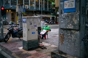 Bác tài xế Grab lớn tuổi ngồi đọc báo