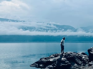 Boy on the rock near lake