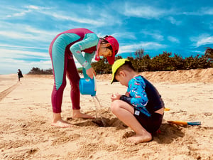 2 kids playing with sand on the beach