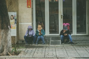 Những phụ nữ lướt điện thoại bên lề đường