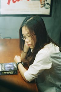 Cô gái đang nhắm mắt nghỉ ngơi trên bàn