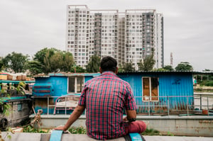 Man sitting and looking at a boathouse