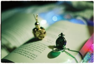 Vintage pocket watch with metal chain on open book pages with magical bokeh lights background