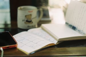 Cozy workspace with calendar, notebook and bear mug