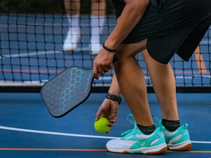 Man picking the pickleball