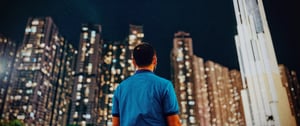 Man in blue t-shirt looking at buildings
