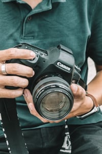 A hand holding Canon camera