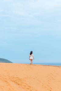 Girl walking on a sand hill