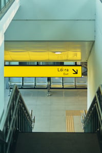 A yellow LED exit sign at a metro station in Ho Chi Minh City