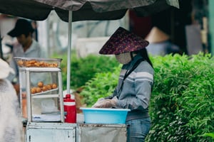 Người phụ nữ bán bánh cam với chiếc nón lá phong cách