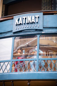 2 girls looking at smartphones in a Katinat Coffee