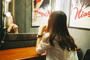 Một cô gái xinh đẹp đang soi gương