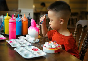 Một em bé đang tô màu tượng