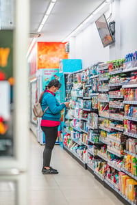 A shopper reading a product packaging